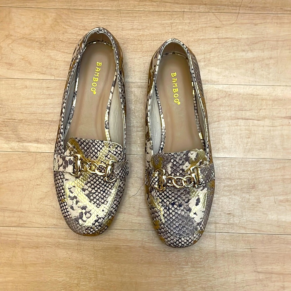 Snakeskin flats with gold accent.